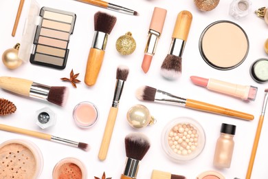 Photo of Different makeup brushes, decorative cosmetics and Christmas decor on white background, flat lay