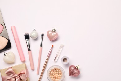 Photo of Different makeup brushes, decorative cosmetics and Christmas decor on white background, flat lay. Space for text