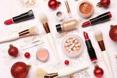 Photo of Different makeup brushes, decorative cosmetics and Christmas decor on white background, flat lay