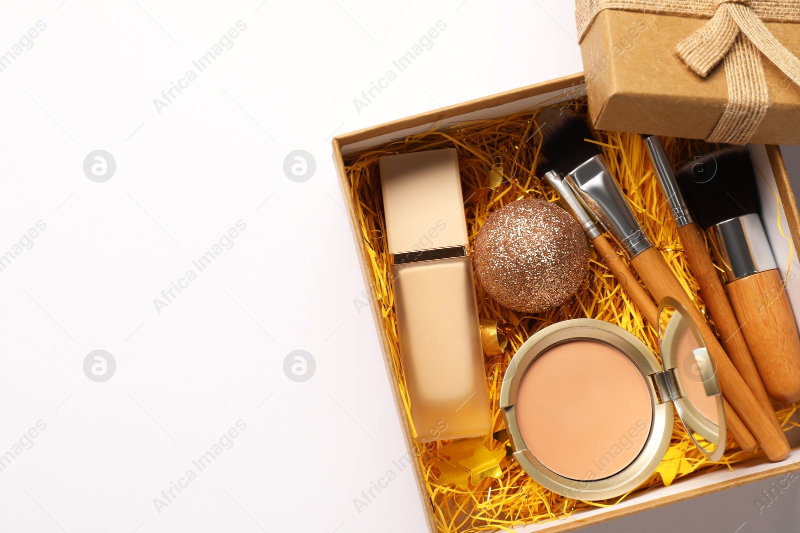 Photo of Makeup brushes, decorative cosmetics and Christmas decor in box on white background, top view. Space for text