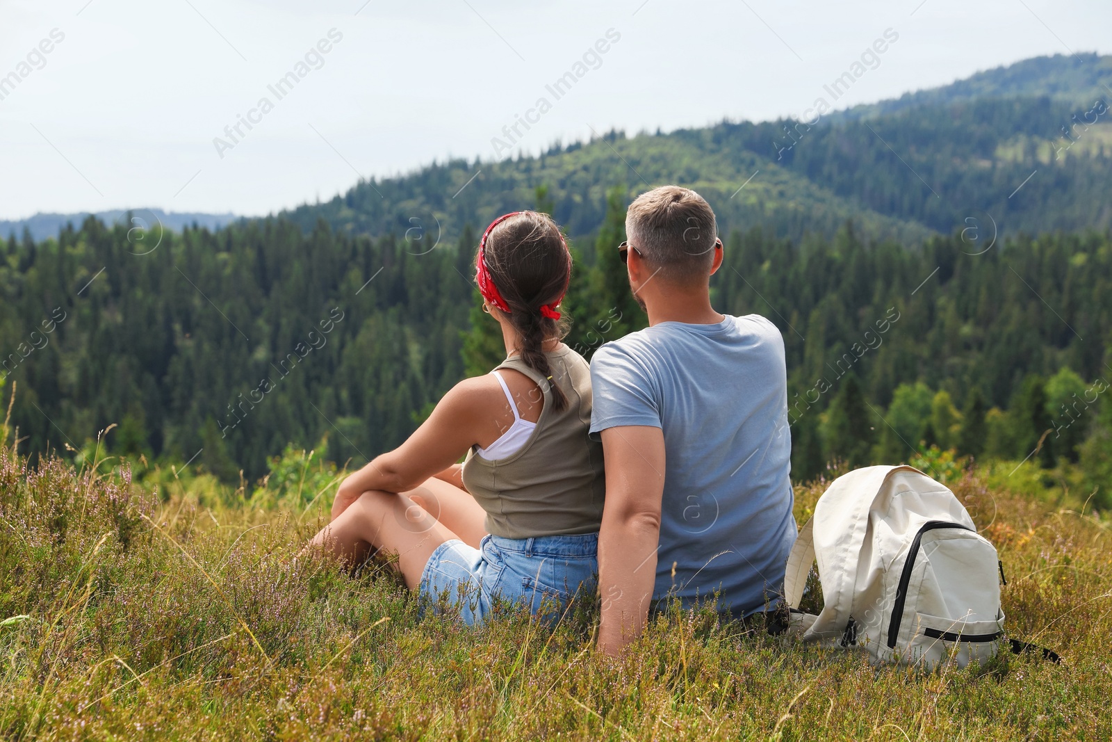 Photo of Couple with backpack enjoying picturesque landscape, back view. Active tourism