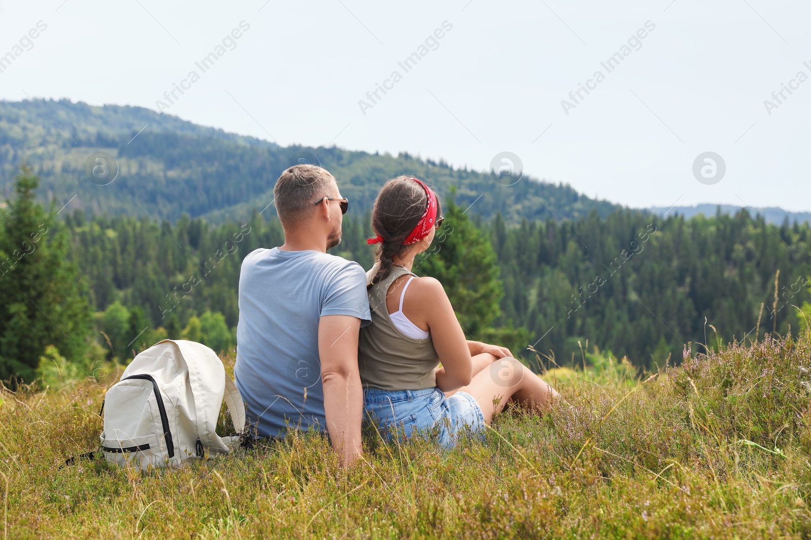 Photo of Couple with backpack enjoying picturesque landscape, back view. Active tourism