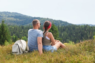 Photo of Couple with backpack enjoying picturesque landscape, back view. Active tourism