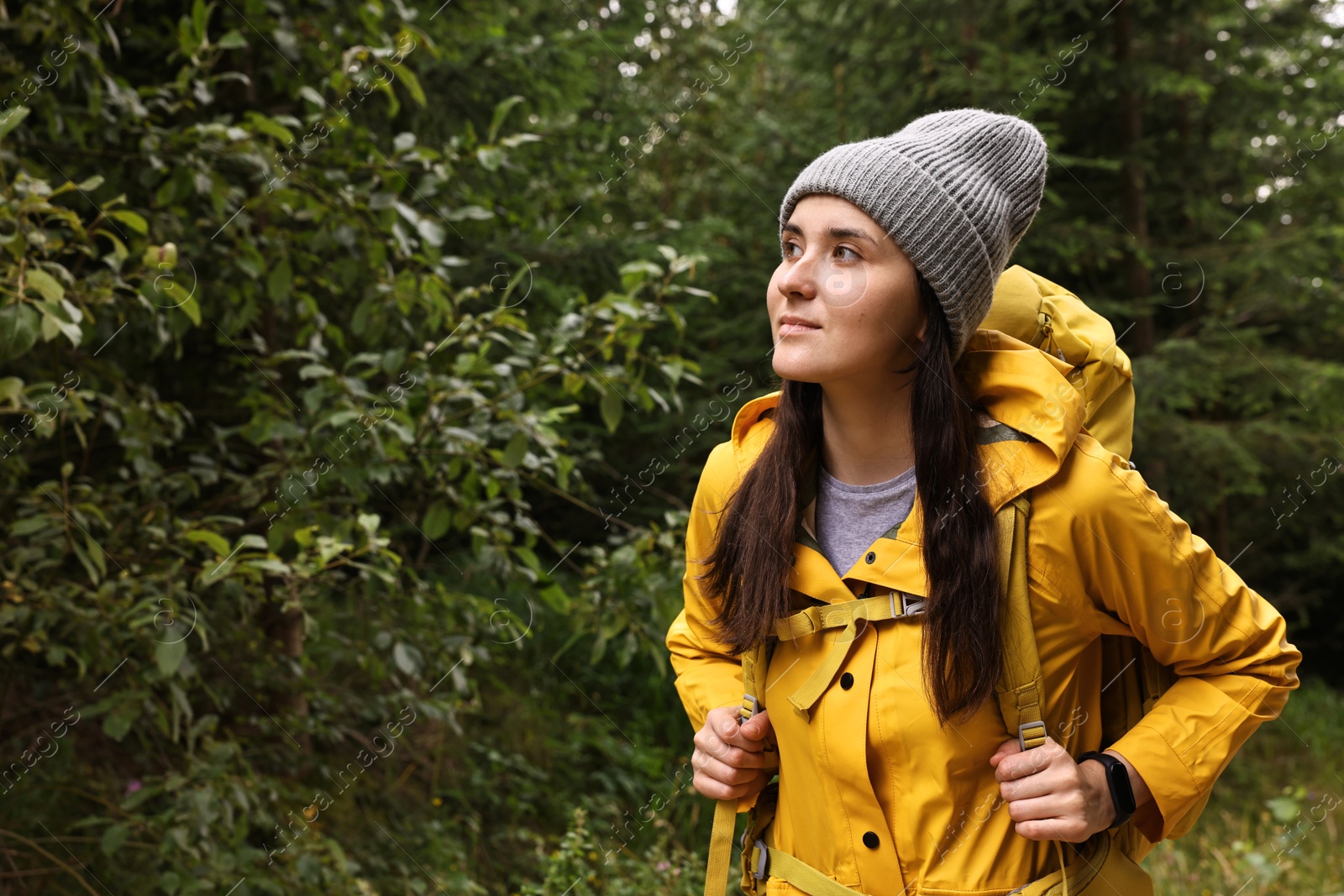 Photo of Young hiker with backpack in forest, space for text