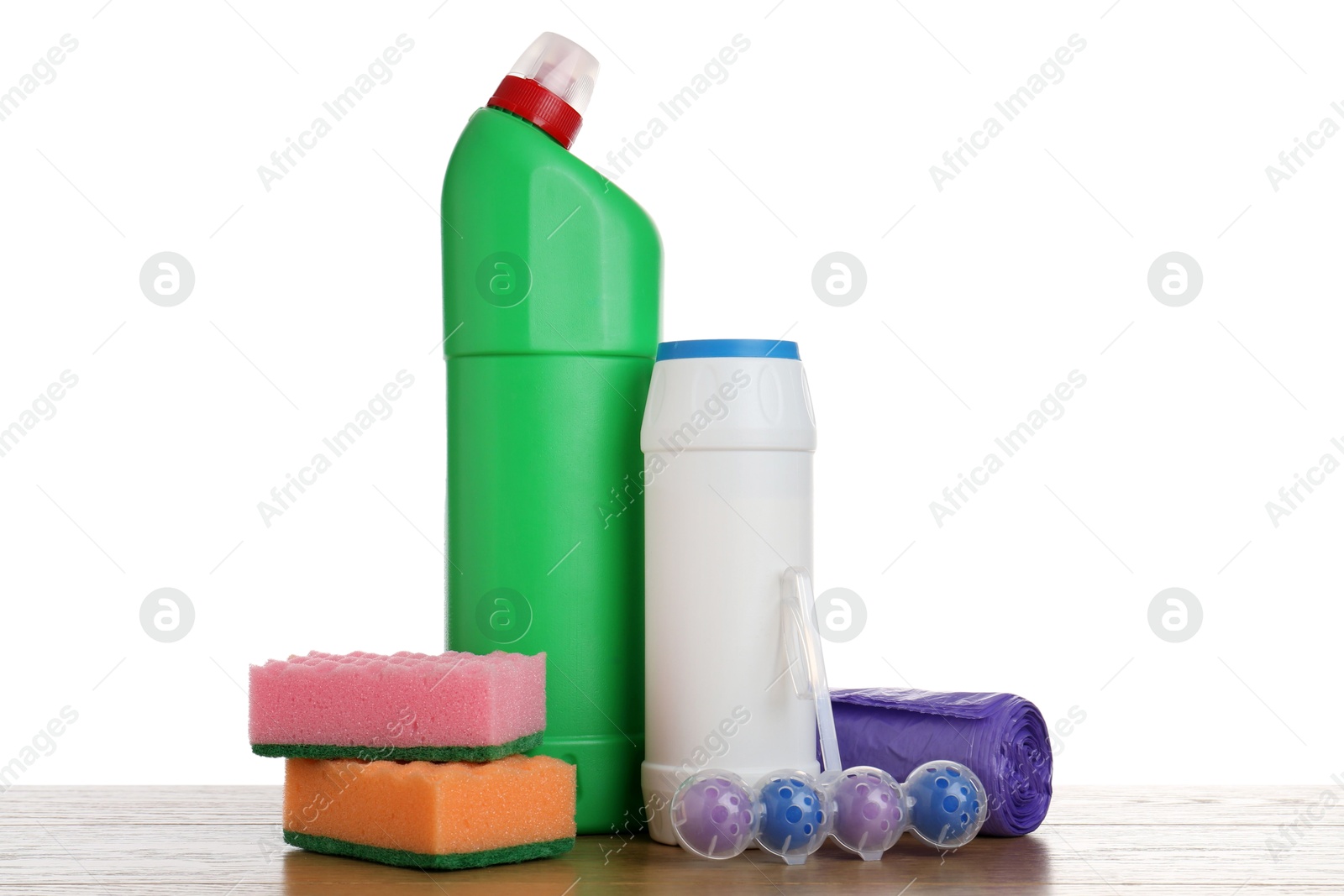 Photo of Different toilet cleaners, sponges and trash bags on wooden table against white background