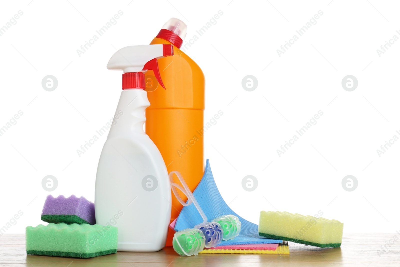 Photo of Different toilet cleaners, sponges and napkins on wooden table against white background