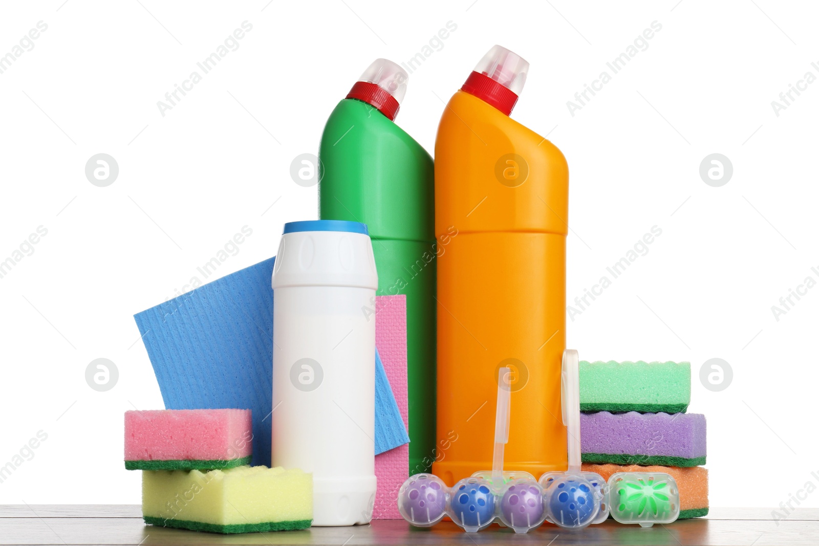 Photo of Different toilet cleaners, sponges and rag on wooden table against white background