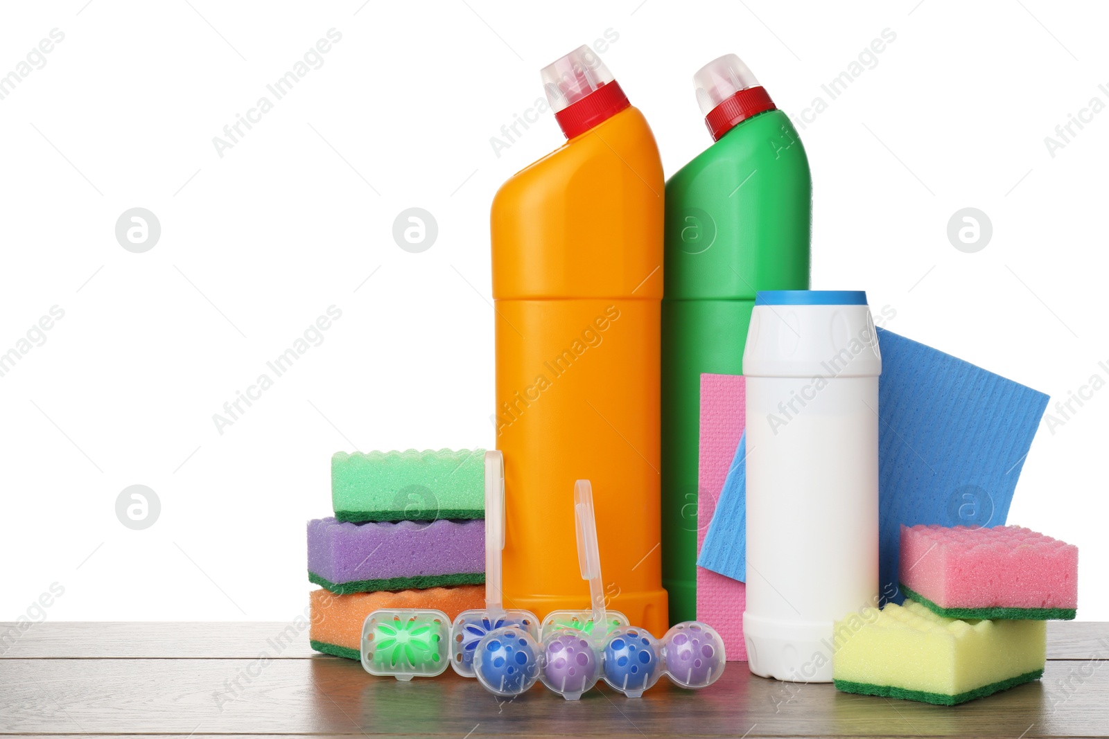 Photo of Different toilet cleaners, sponges and rag on wooden table against white background