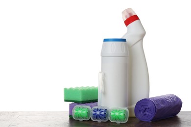 Photo of Different toilet cleaners, sponges and trash bags on wooden table against white background