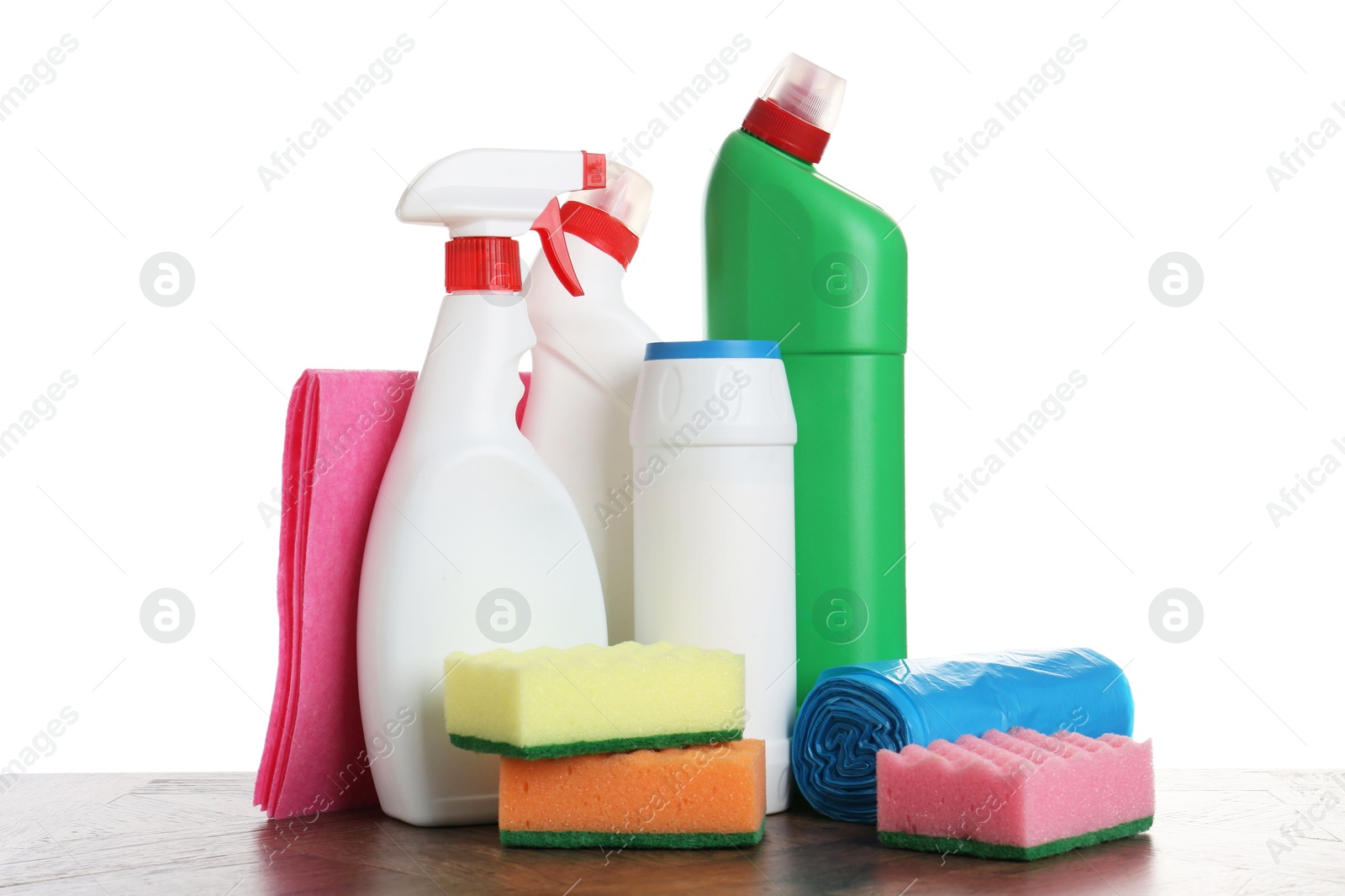 Photo of Different toilet cleaners, sponges, rag and trash bags on wooden table against white background