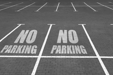 Empty outdoor parking lot with painted markings on brick pavement