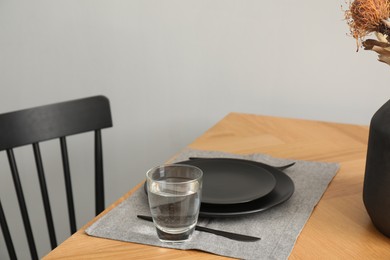 Photo of Stylish table setting with black dishware in dining room