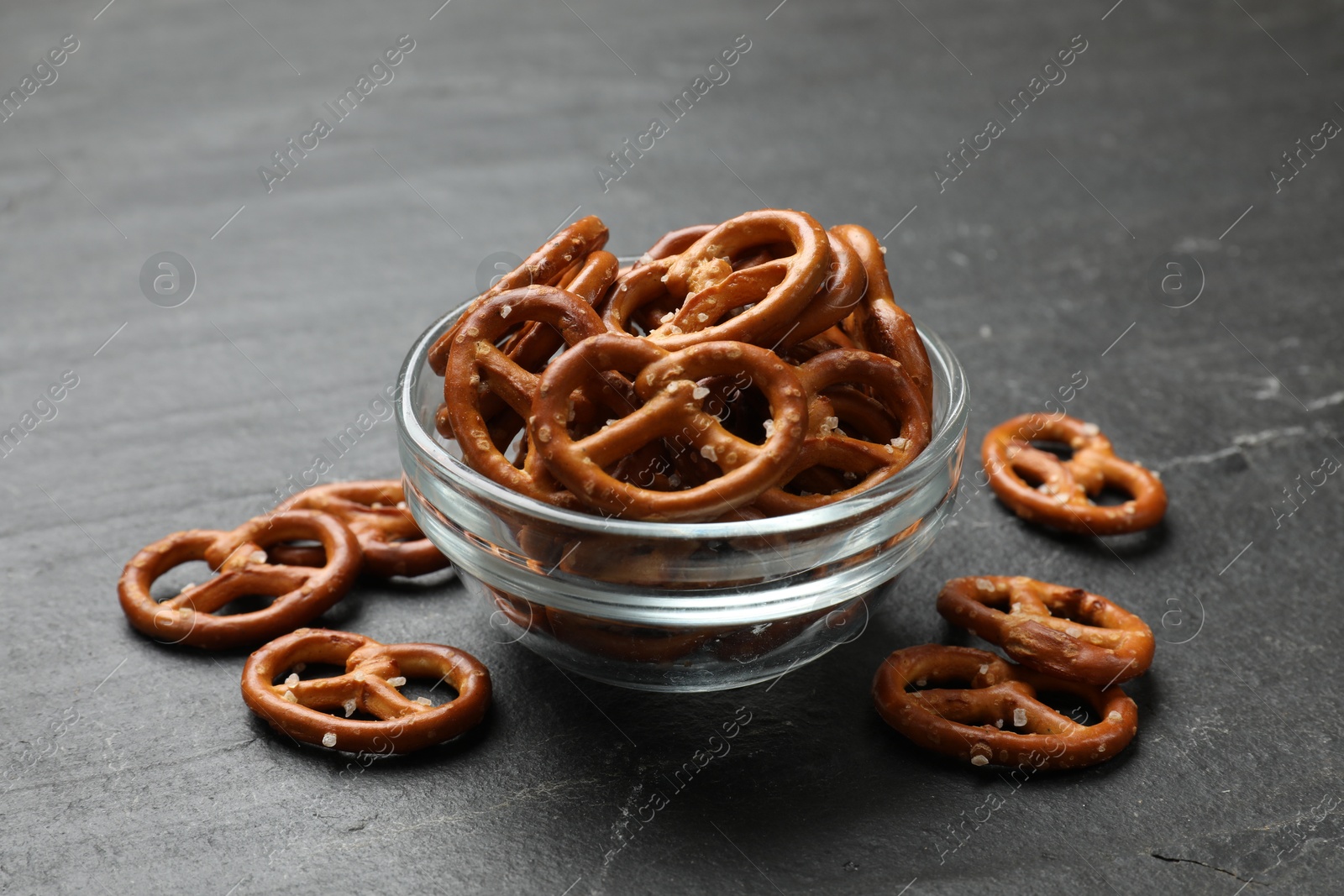 Photo of Delicious salty pretzel crackers on black table, closeup