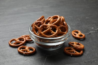 Photo of Delicious salty pretzel crackers on black table, closeup