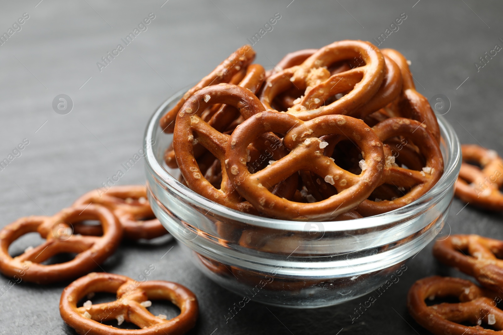 Photo of Delicious pretzel crackers on black table, closeup