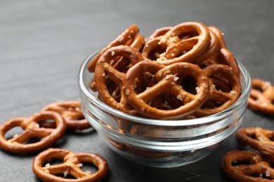 Photo of Delicious pretzel crackers on black table, closeup