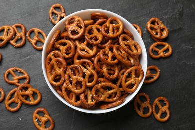 Photo of Delicious pretzel crackers on black table, flat lay