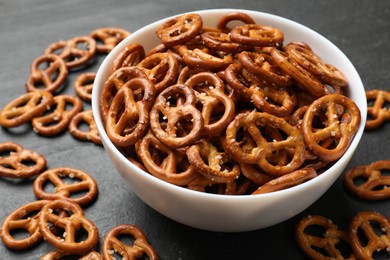 Photo of Delicious pretzel crackers on black table, closeup