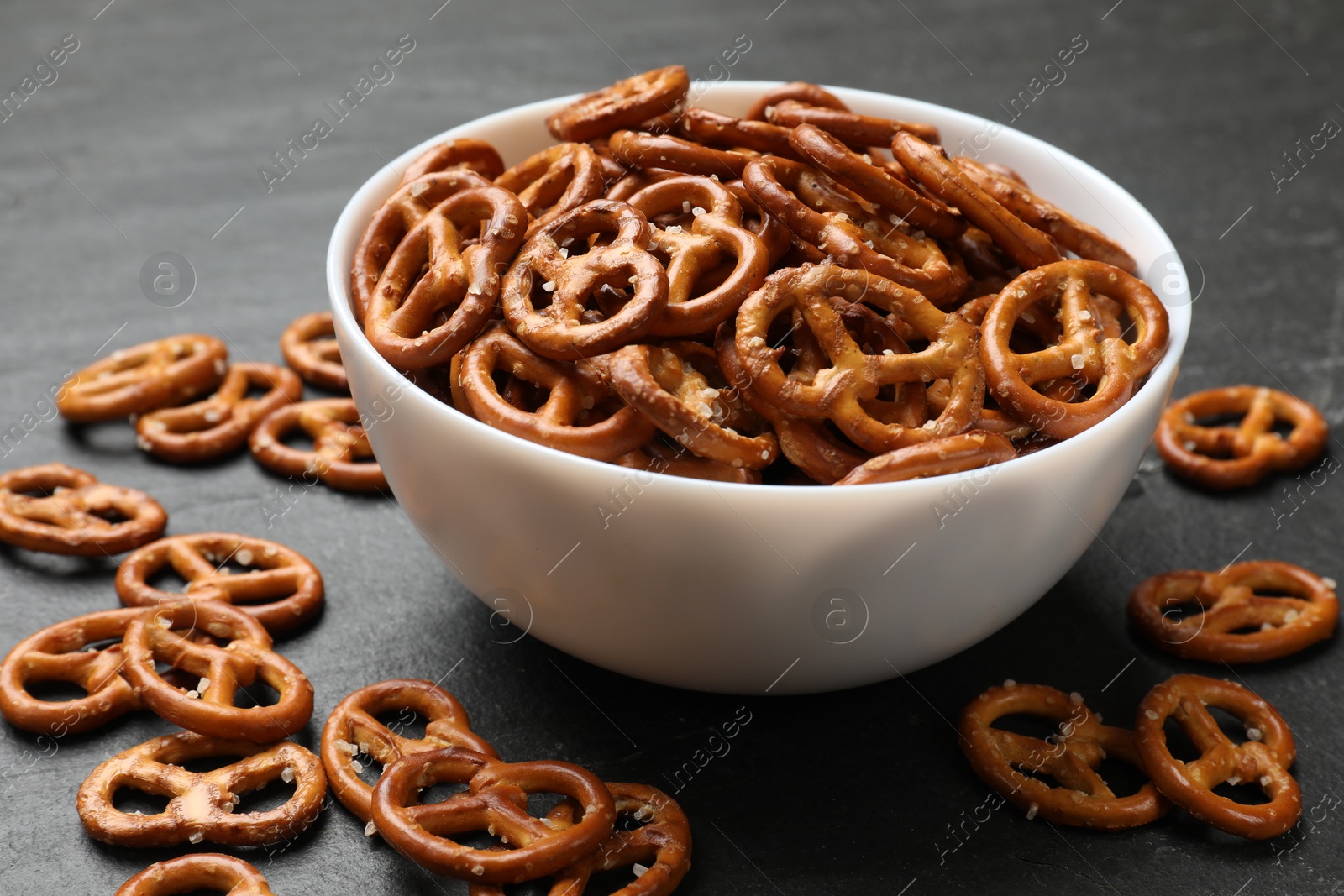 Photo of Delicious pretzel crackers on black table, closeup