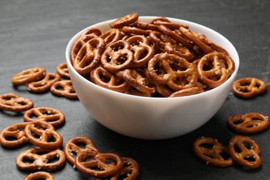 Photo of Delicious pretzel crackers on black table, closeup