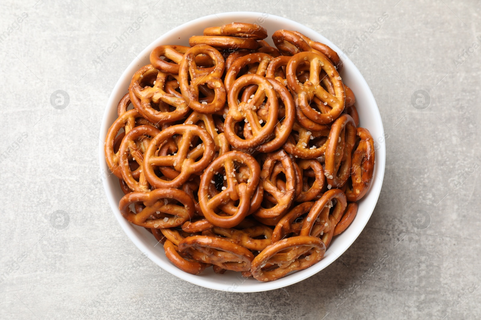 Photo of Delicious pretzel crackers on light table, top view