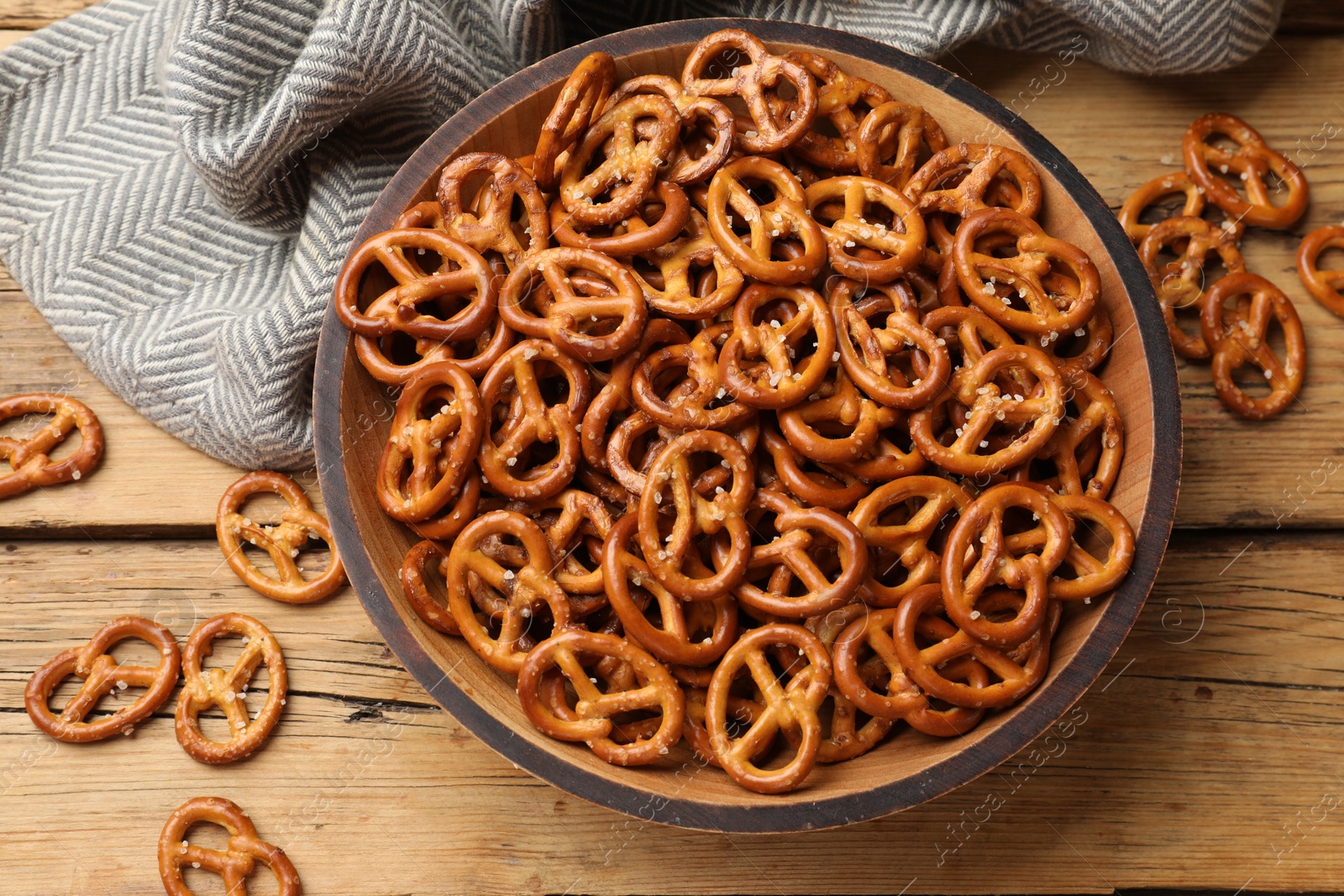 Photo of Delicious pretzel crackers on wooden table, flat lay