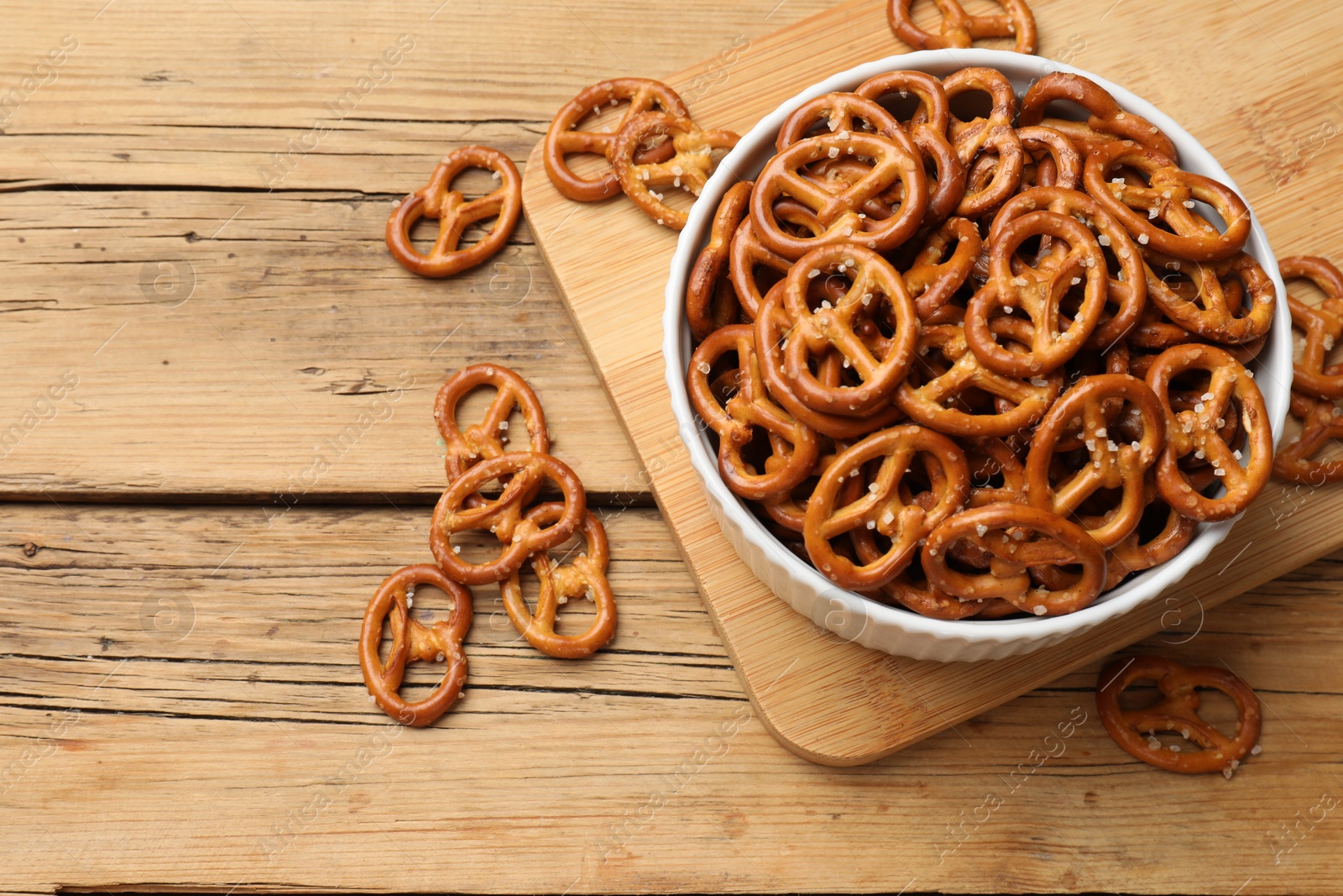 Photo of Delicious pretzel crackers on wooden table, flat lay