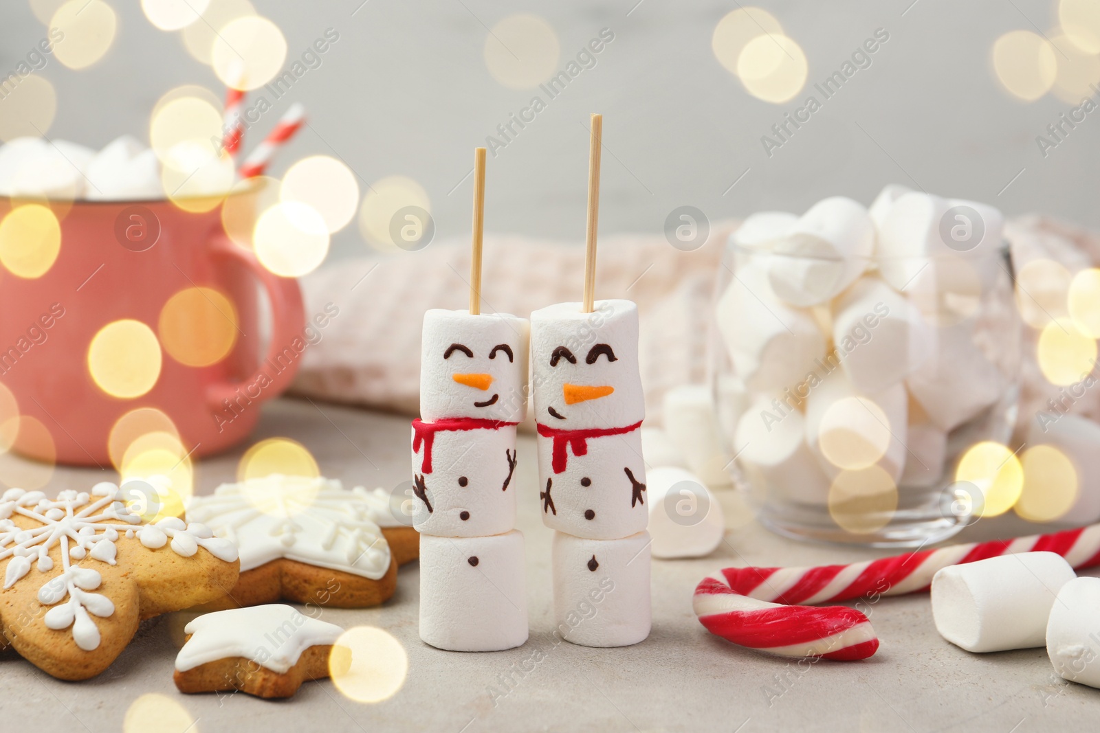 Photo of Funny snowmen made of marshmallows and other sweets on light table