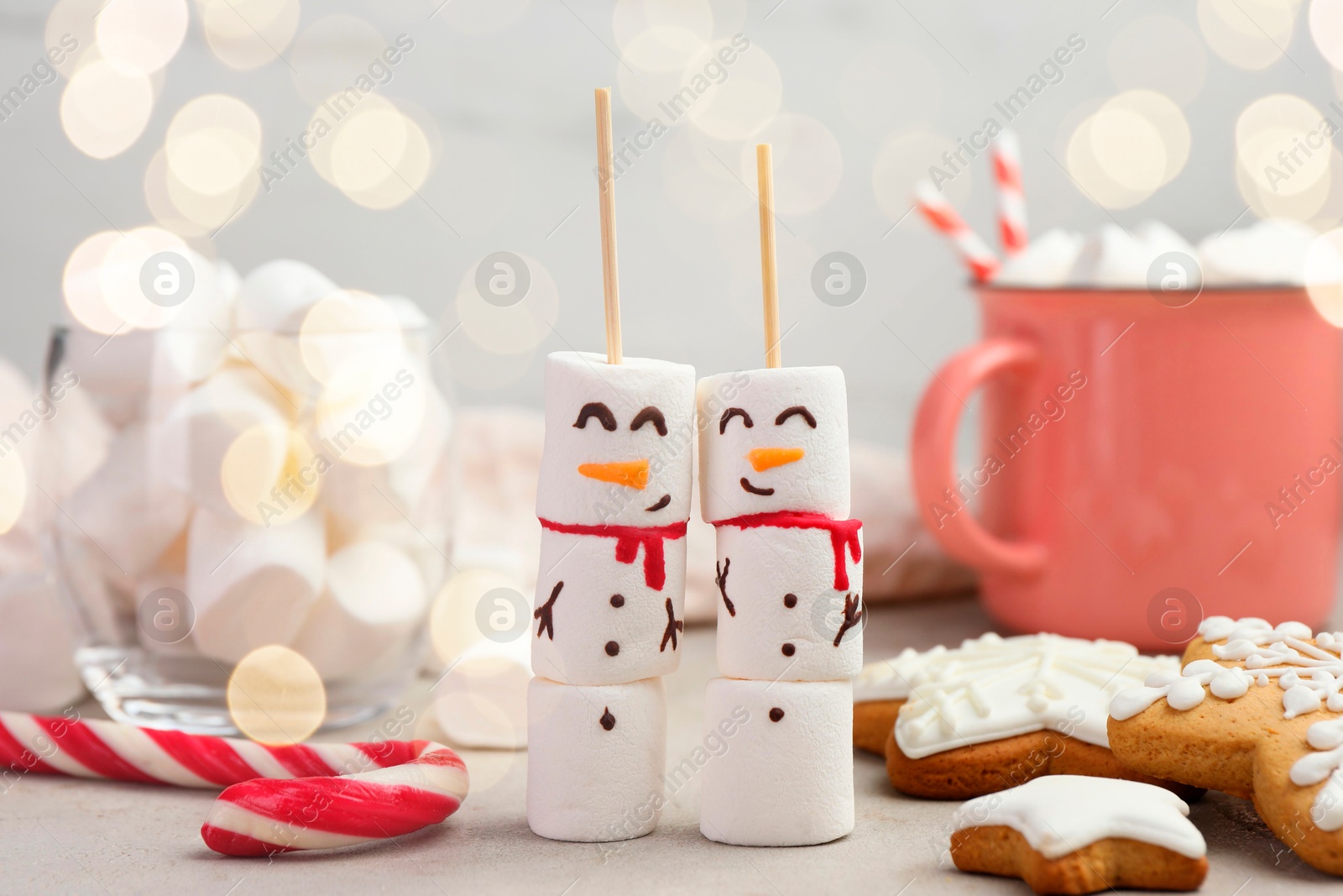 Photo of Funny snowmen made of marshmallows and other sweets on light table