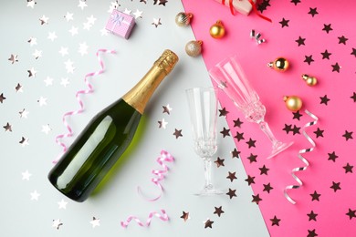 Photo of Flat lay composition with confetti and bottle of sparkling wine on color background. Christmas decor