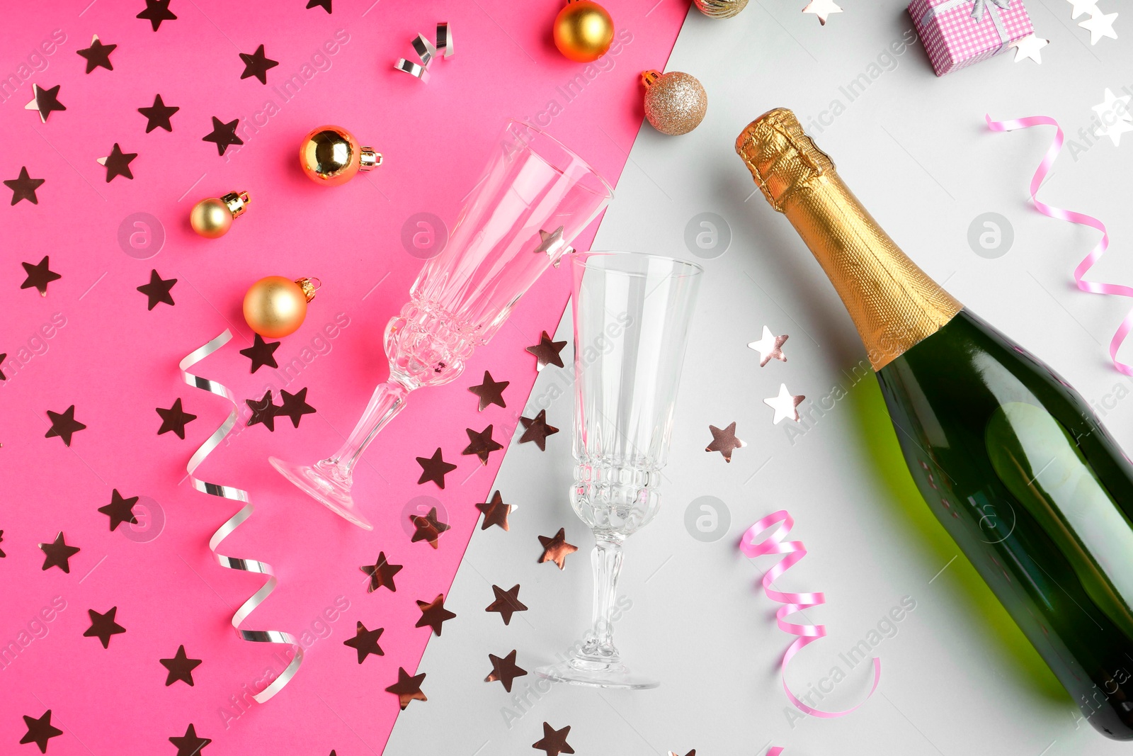 Photo of Flat lay composition with confetti and bottle of sparkling wine on color background. Christmas decor