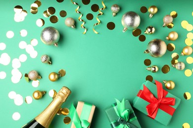 Photo of Flat lay composition with confetti and bottle of sparkling wine on green background, space for text. Christmas decor