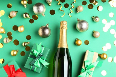 Photo of Flat lay composition with confetti and bottle of sparkling wine on green background. Christmas decor