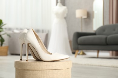 Photo of Beautiful wedding dress on mannequin and shoes in boutique, selective focus