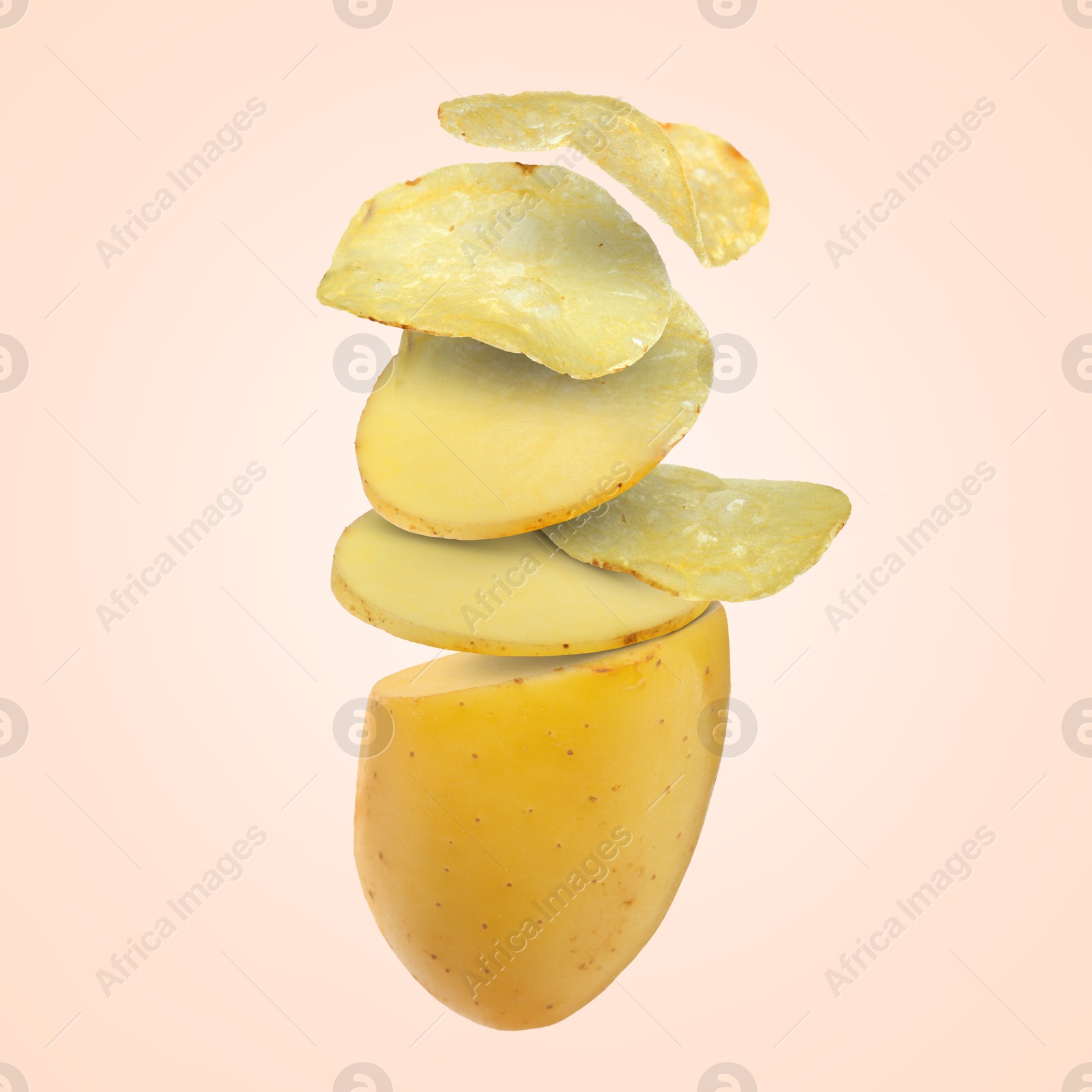 Image of Raw potato turning into tasty crispy chips in air on beige background