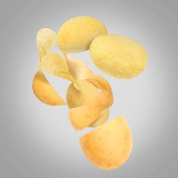 Raw potato turning into tasty crispy chips in air on gray background