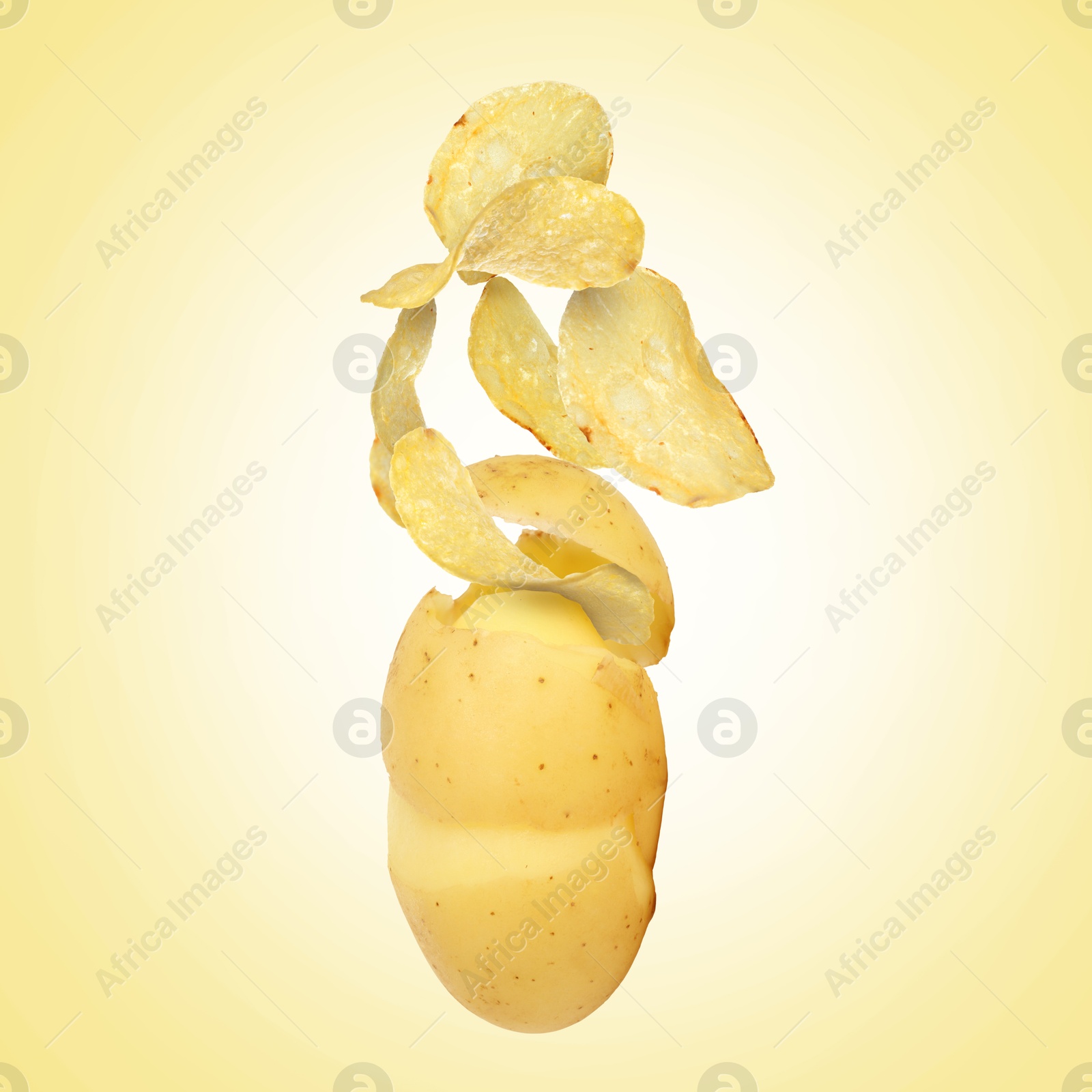 Image of Raw potato turning into tasty crispy chips in air on yellow gradient background