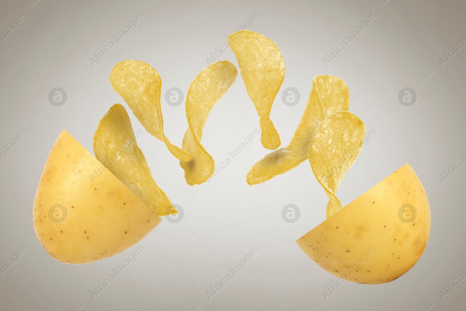 Image of Raw potato turning into tasty crispy chips in air on gray background