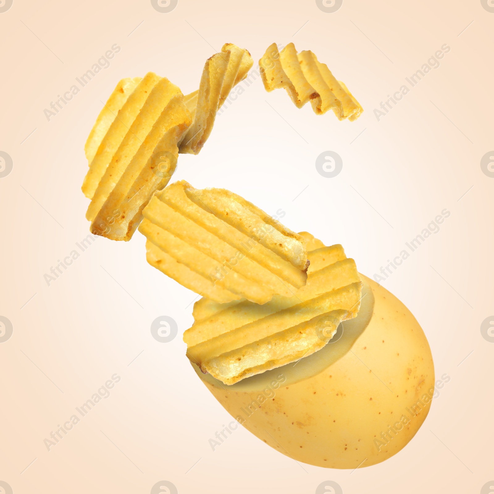 Image of Raw potato turning into tasty crispy chips in air on beige gradient background