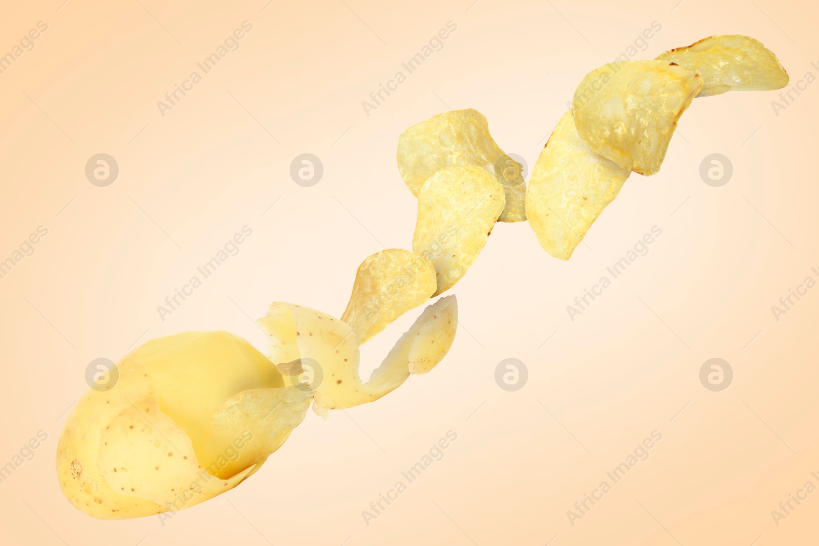 Image of Raw potato turning into tasty crispy chips in air on beige background