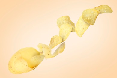 Image of Raw potato turning into tasty crispy chips in air on beige background