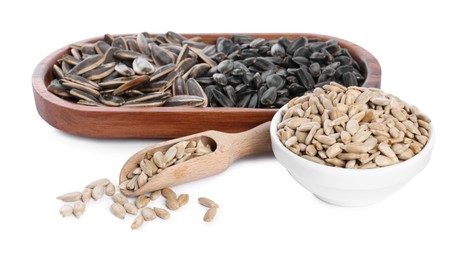 Different sunflower seeds, wooden plate, scoop and bowl isolated on white