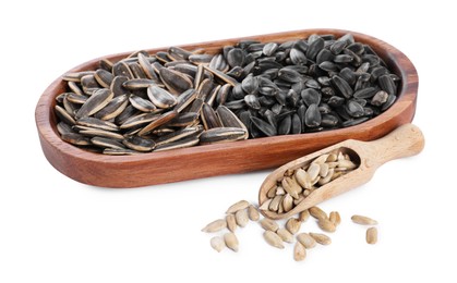 Photo of Different sunflower seeds, wooden plate and scoop isolated on white