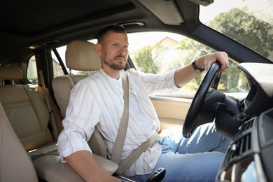 Photo of Man holding steering wheel while driving car