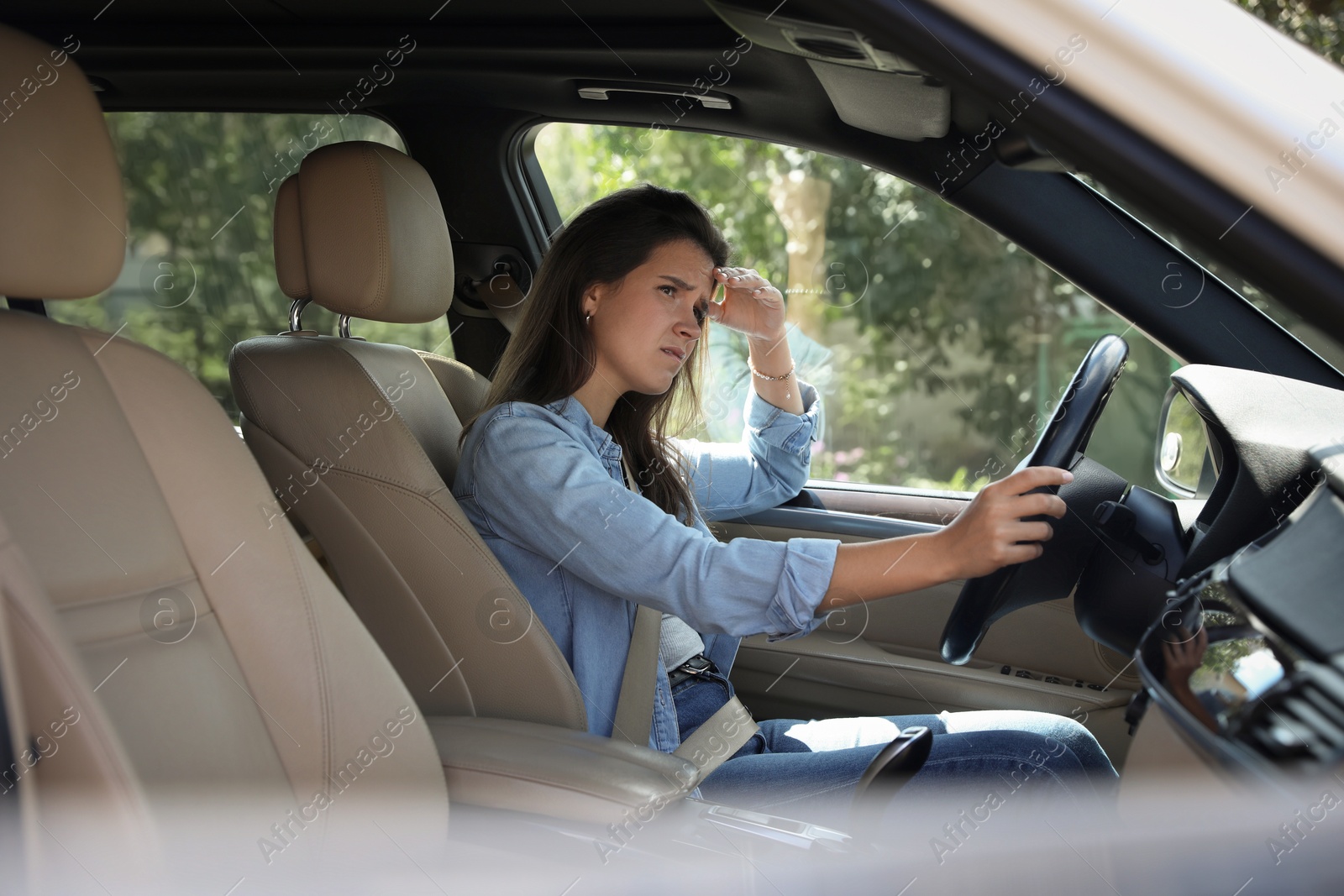 Photo of Sad woman holding steering wheel while driving car