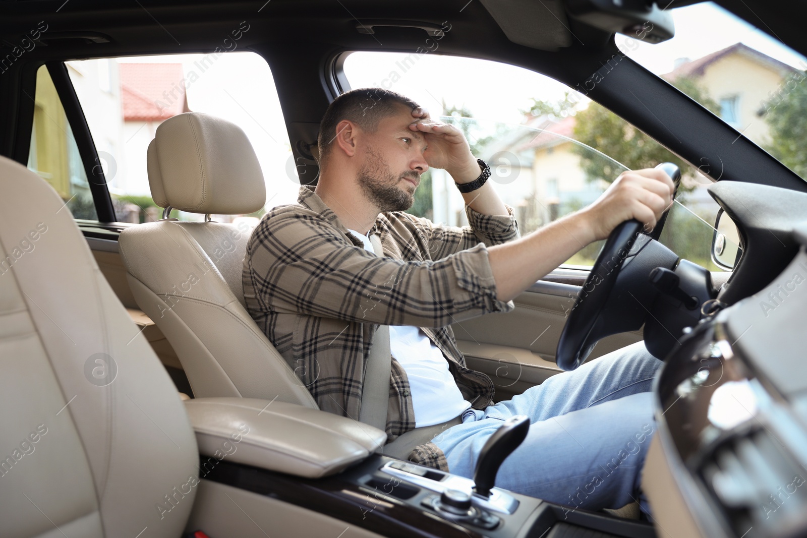 Photo of Tired man holding steering wheel while driving car