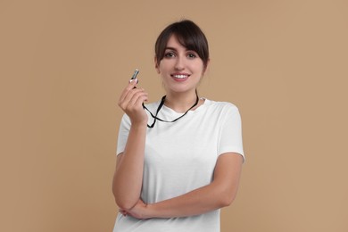 Photo of Happy woman with whistle on beige background