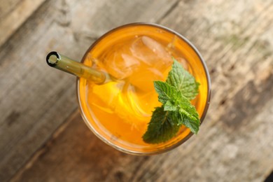 Glass of tasty refreshing drink and straw on wooden table, top view