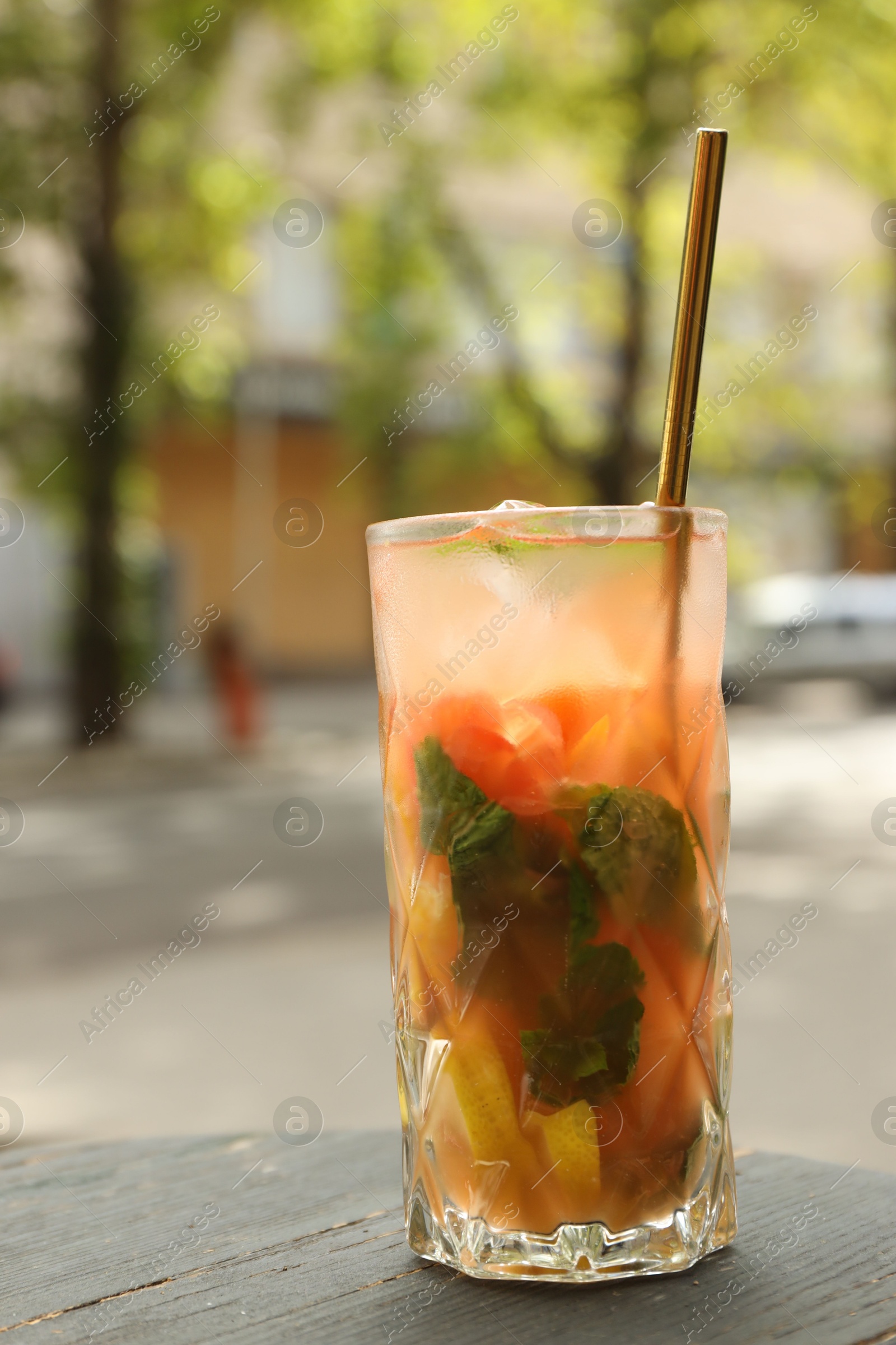 Photo of Glass of tasty refreshing drink and straw on table