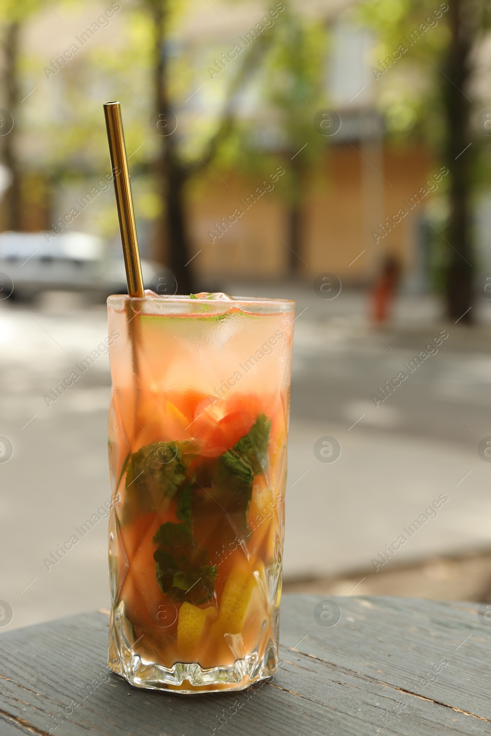 Photo of Glass of tasty refreshing drink and straw on table